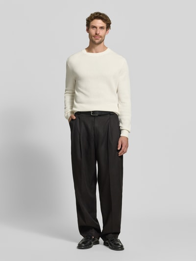 Męską model nosi Regular Fit Pullover aus reiner Baumwolle Modell 'Lalex' von BOSS, ecru sweter, czarne szerokie spodnie, Ganzkörperansicht von vorne.