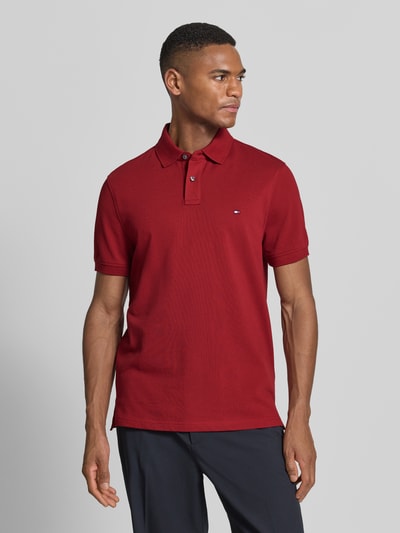 Männermodel trägt Regular Fit Poloshirt aus Baumwoll-Mix von Tommy Hilfiger, Optik: Unifarben, Logo-Stitching, Ganzkörperansicht von vorne.