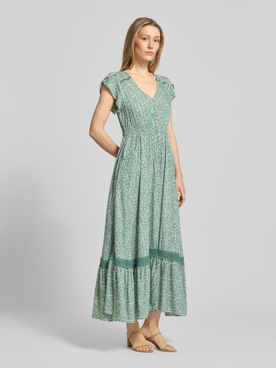 Modelka kobieca nosi Midikleid aus Viskose mit Knopfleiste od Apricot, czysta wiskoza, linia A, wzór allover, dekolt V, długość pleców w rozmiarze S: 114 cm, szerokość w rozmiarze S: 32 cm, długość rękawa w rozmiarze S: 10 cm, kolor zielony ze wzorem, widok całej sylwetki z przodu.