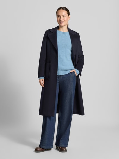 Frauenmodel trägt Regular Fit Pullover aus Alpaka-Mix Modell 'GHIACCI' von Max Mara in Hellblau, kombiniert mit dunkelblauem Mantel und Jeans, Damen Pullover von Weekend Max Mara, Ganzkörperansicht von vorne.
