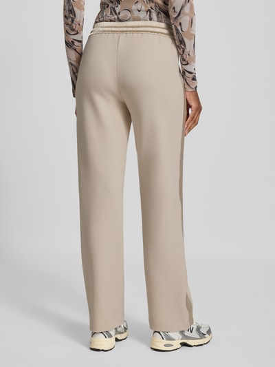 Frauenmodel trägt Sweatpants mit elastischem Bund und Tunnelzug von Marc Cain in Beige, Baumwoll-Mix, Relaxed Fit, Ganzkörperansicht Rückansicht.