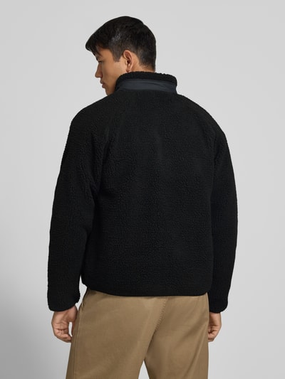 Männermodel trägt schwarze Teddyjacke mit Struktur, Modell 'PRENTIS LINER' von Carhartt Work In Progress, Rückenansicht, Herrenjacke.