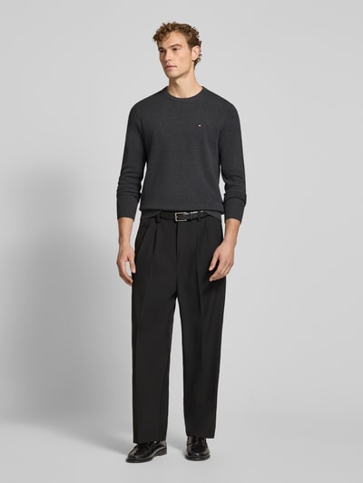 Męski model nosi Regular Fit Pullover aus reiner Baumwolle von Tommy Hilfiger, ciemny odcień, gładka struktura, Ganzkörperansicht von vorne.