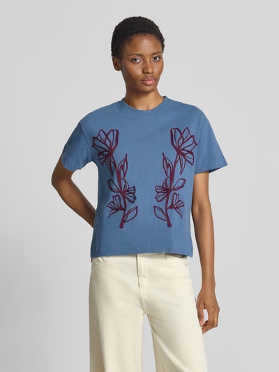 Vrouwenmodel draagt blauw Regular Fit T-shirt uit pure katoen van Jake*s Casual met rode bloemenmotief, nahaufname bovenlichaam.