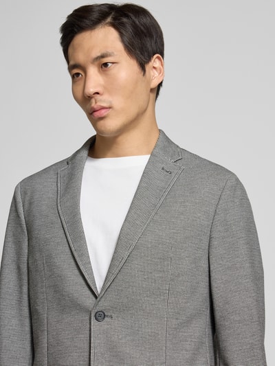 Męski model nosi Slim Fit 2-Knopf-Sakko mit Strukturmuster von Pierre Cardin, szary materiał ze stretchu, krój slim fit, struktura, detal kołnierza i kieszeni, detalowa faktura tkaniny, zdjęcie typu nahaufnahme górnej części ciała