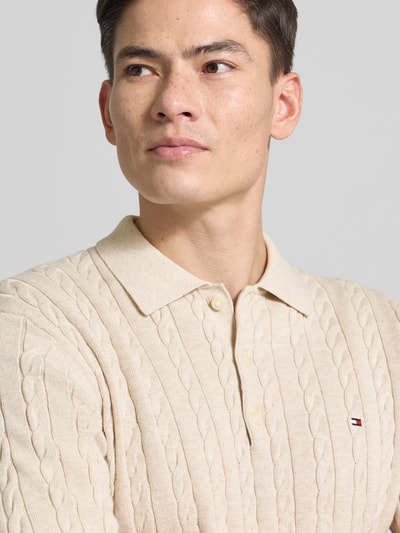 Männermodel trägt Regular Fit Strickpullover aus reiner Baumwolle von Tommy Hilfiger mit Zopfmuster, Optik: Unifarben, Nahaufnahme Oberkörper.