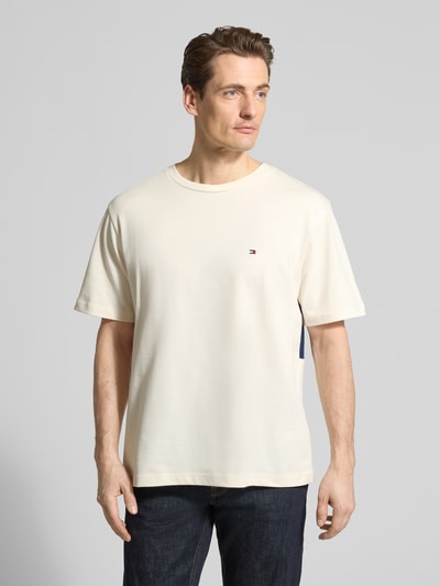 Männermodel trägt Relaxed Fit T-Shirt aus reiner Baumwolle von Tommy Hilfiger, unifarben, Logo-Stitching, Ganzkörperansicht von vorne.
