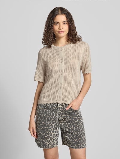 Frauenmodel trägt Regular Fit Strickjacke aus reiner Baumwolle Modell 'SCOUT' von PIECES in Beige, grobe Textur, Damen Strickjacke, Ganzkörperansicht von vorne.