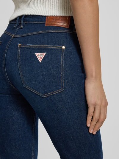 Kobiece modelka nosi Jeansy z 5 kieszeniami od Guess, mieszanka bawełny, krój slim fit, zapięcie na guzik, detal z tyłu, zbliżenie na biodra.