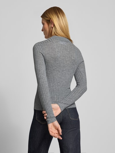 Vrouwenmodel draagt Henley-Shirt aus Wolle van Style Icon Collection, grijs met riblook, skinny fit, polokraag, met lange mouwen, tricotlook, puur katoen, ruglengte maat S 59 cm, mouwlengte maat S 66 cm, volledig zicht van achteren.
