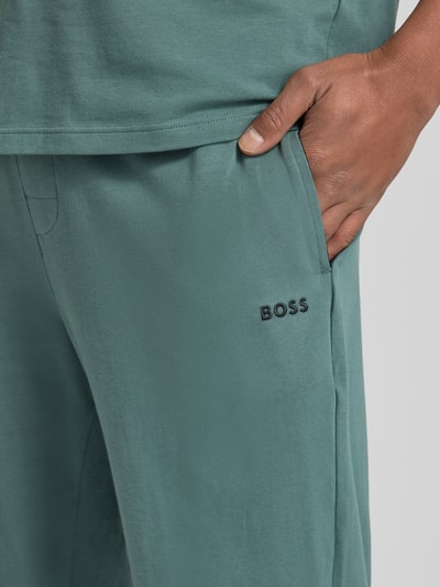 Männermodel trägt Comfort Fit Sweathose aus Baumwoll-Mix Modell 'MIX&MATCH PANTS' von BOSS, groen, label stitching, zijzakken, Nahaufnahme Oberkörper.