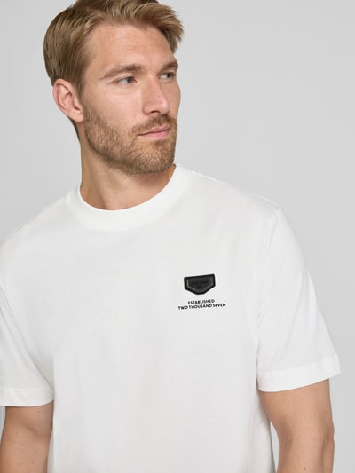 Männermodel trägt Relaxed Fit T-Shirt aus reiner Baumwolle von Antony Morato, weiß mit kleinem Logo-Detail, Nahaufnahme Oberkörper.