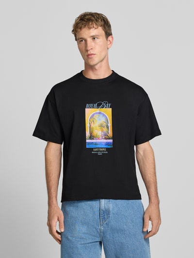 Männermodel trägt T-Shirt mit Motiv-Print Modell 'SANREMO' von JACK & JONES in Schwarz, bunte Grafik, reine Baumwolle, Regular Fit, Nahaufnahme Oberkörper.