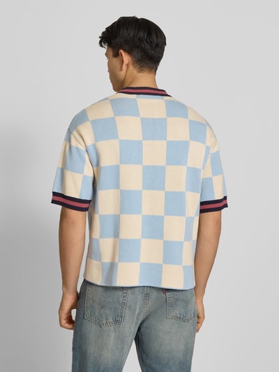 Männermodel trägt Strickshirt mit Label-Stitching Modell 'Victory' von PROHIBITED in Beige und Blau, reine Baumwolle, Relaxed Fit, Ganzkörperansicht Rückansicht.
