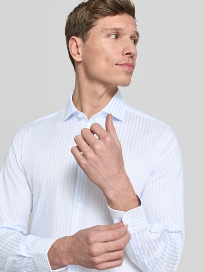 Männermodel trägt Slim Fit Businesshemd aus Baumwoll-Mix von Tommy Hilfiger Tailored mit dezentem Streifenmuster, Nahaufnahme Oberkörper.