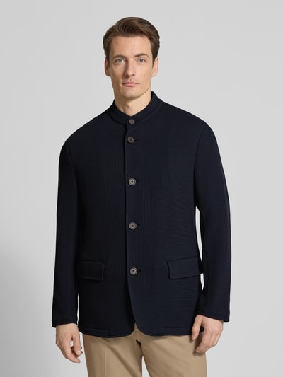Männermodel trägt Slim Fit Sakko mit Stehkragen und Pattentaschen von Emporio Armani, dunkelblauer Material-Mix mit Viskose-Anteil, Knopfleiste, strukturierte Oberfläche, Ganzkörperansicht von vorne.