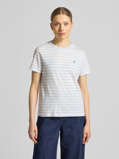 Frauenmodel trägt T-Shirt mit Rundhalsausschnitt und Label-Stitching von Gant aus Reine Baumwolle im Regular-Fit, Streifenmuster, Ganzkörperansicht von vorne. Rückenlänge bei Größe S: 56 cm.
