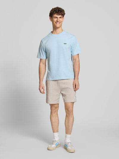 Männermodel trägt Regular Fit Sweatshorts aus Baumwoll-Mix Modell 'NUWAFFLO' von HUGO, Optik: Unifarben, Nahaufnahme Ganzkörperansicht von vorne. Baumwoll-Mix, Label-Patch, Tunnelzug, elastischer Bundabschluss, seitliche Eingrifftaschen, Gesäßtasche.