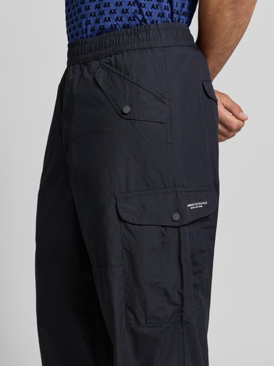 Männermodel trägt Wide Fit Cargo-Hose mit katoenmix van Armani Exchange, Materiaalmix met katoen, elastische band, cargozakken, detailaufnahme rechterbeen