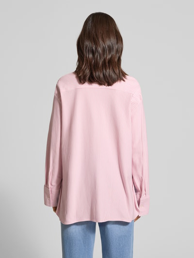 Frauenmodel trägt Oversized Langarmbluse aus Baumwoll-Mix von Tommy Hilfiger in Rosa mit feinen Streifen, Ganzkörperansicht Rückansicht.