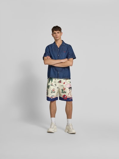 Männermodel trägt Seidenshorts aus reiner Seide von Dsquared2, bunte Muster mit Flamingos, lockere Passform, Ganzkörperansicht von vorne.
