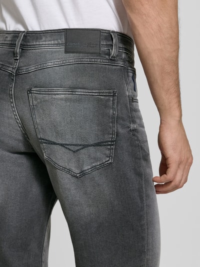 Männermodel trägt Bermudas im 5-Pocket-Design mit aufgeschlagenem Saum von Christian Berg Men, grauer Baumwoll-Mix, Detailaufnahme Rückansicht. Bundweite 41 cm, Innenbeinlänge 26 cm, Label-Detail sichtbar.