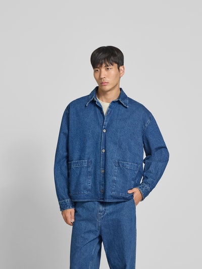 Männermodel trägt Freizeithemd in Denim-Optik von WON HUNDRED aus reiner Baumwolle mit Relaxed-Fit, aufgesetzten Taschen, Knopfleiste, Ganzkörperansicht von vorne.