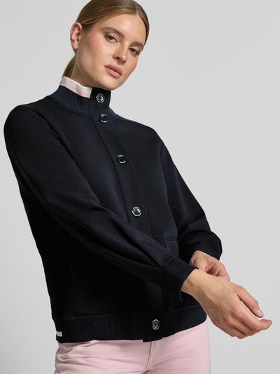 Vrouwenmodel draagt 'Sweatjacke mit Stehkragen und Knopfleiste' van Marc Cain in donkerblauw katoenmix met stretch, steekzakken, regular fit, opstaande kraag, knoopsluiting, voorkant bovenlichaam close-up.