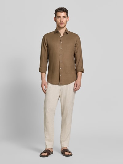 Männermodel trägt Regular Fit Leinenhemd mit Kentkragen von Christian Berg Men in Braun, glatte Struktur, vorne geknöpft, Ganzkörperansicht von vorne.