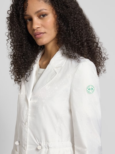 Frauenmodel trägt Regular Fit Blazer mit aufgesetzten Taschen von Marc Cain, weißer Allover-Motiv-Print, tailliert, Nahaufnahme Oberkörper.
