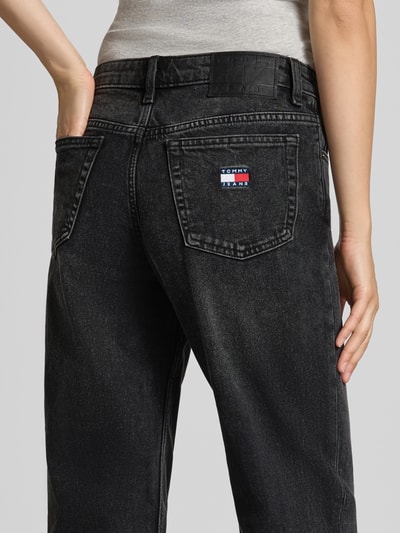 Frauenmodel trägt Straight Fit Jeans aus Baumwoll-Mix von Tommy Jeans in Schwarz mit sichtbarem Label auf der Gesäßtasche, Nahaufnahme Rückansicht. Damen Straight Fit Jeans von Tommy Jeans.
