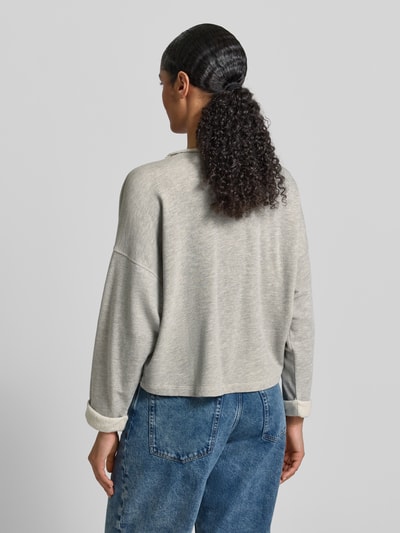 Frauenmodel trägt Oversized Sweatshirt mit Label-Print von American Vintage aus Baumwoll-Mix in Hellgrau, gerippter Rundhalsausschnitt, Ganzkörperansicht Rückansicht.