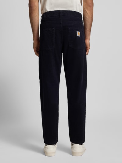 Männermodel trägt Stoffhose mit 5-Pocket-Design von Carhartt Work In Progress, reine Baumwolle, gerader Schnitt, Ganzkörperansicht Rückansicht.