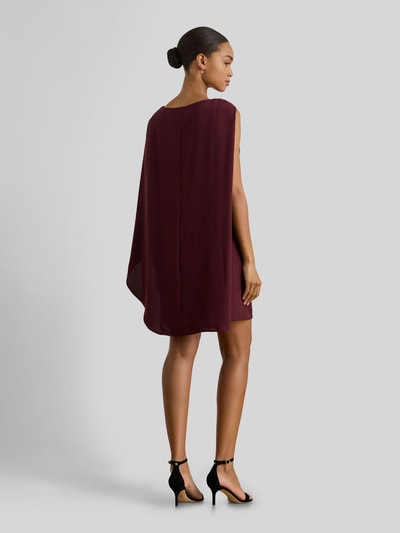 Vrouwenmodel draagt Tailliertes Cocktailkleid mit Umhang van Lauren Ralph Lauren in effen bordeauxrood, getailleerde fit, mini-lengte, mouwloos, zonder zakken, met metalen accenten, naadrits, U-boothals, achteraanzicht volledige lichaamsopname.
