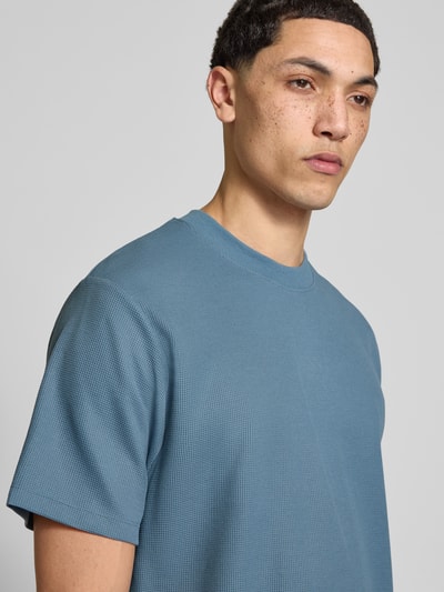 Männermodel trägt T-Shirt mit Rundhalsausschnitt Modell 'AUSTIN' von Jack & Jones, Elastischer-Material-Mix, Gerader-Schnitt, Nahaufnahme Oberkörper.