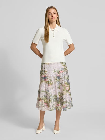 Vrouwenmodel draagt T-Shirt uit viscosemix met polokraag model 'ELBETH' van Ted Baker, aansluitende fit, korte knoopsluiting, crèmekleur, gecombineerd met lichte bloemenrok, gladde texturen, volledige vooraanzicht.
