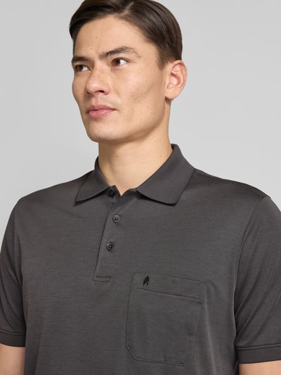 Męski model nosi Regular Fit Poloshirt mit Brusttasche od RAGMAN, bawełna, kieszonka i logo, ciemny kolor, zbliżenie na górę ciała.