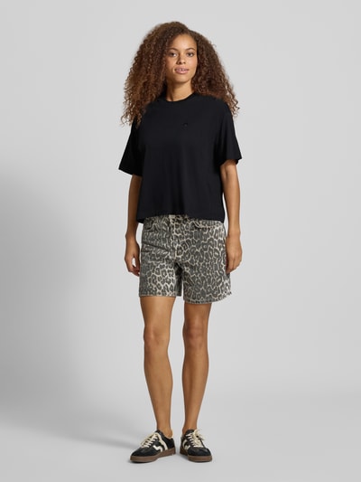 Frauenmodel trägt Regular Fit T-Shirt aus reiner Baumwolle Modell 'CHESTER' von Carhartt Work In Progress in Schwarz, Ganzkörperansicht von vorne. Damen T-Shirt, Stehkragen, Halbarm, Rückenlänge bei Größe S 56 cm.