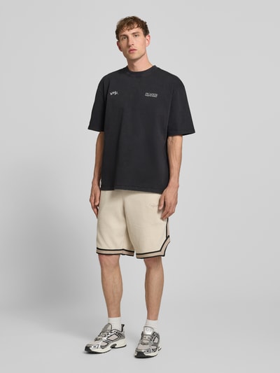 Männermodel trägt Oversized Herren T-Shirt aus reiner Baumwolle mit Label-Print Modell 'Trofa' von PEGADOR, Ganzkörperansicht von vorne.