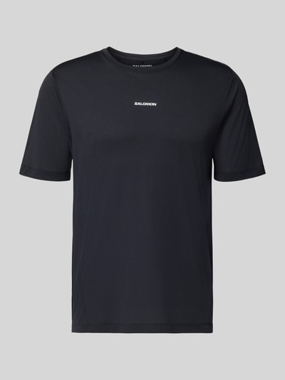 Produktfoto, schwarzes T-Shirt mit Rundhalsausschnitt und Logo von Salomon, glatte Textur, Regular Fit, Rückenlänge M: 69 cm