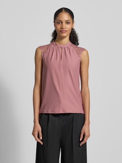 Vrouwenmodel draagt Regular fit blusentop met kant model 'MILLA' van Vero Moda, effen roze, opstaande kraag, kapmouwen, detailopname van voren.