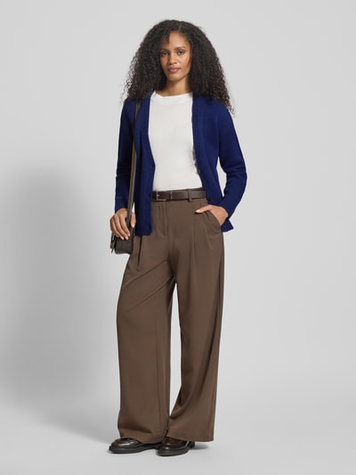 Vrouwenmodel draagt Relaxed Fit Cardigan uit pure wol in brei-look van Fynch-Hatton, V-hals, knoopsluiting, elastische boorden, donkerblauw, combinatie met witte top en bruine broek, voorkant volledig zicht.