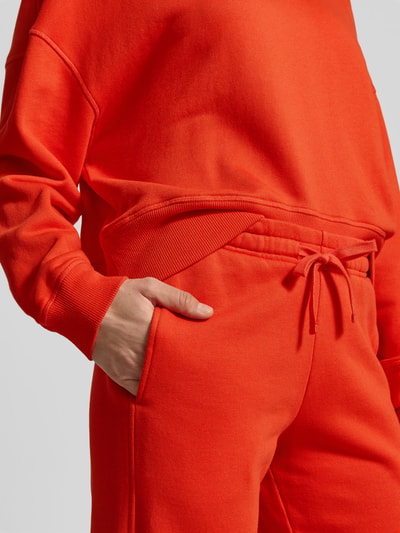 Vrouwenmodel draagt Sweatpants uit katoen-modal-mix van Juvia, los model, elastische tailleband, zijzakken, detailopname van de taille.