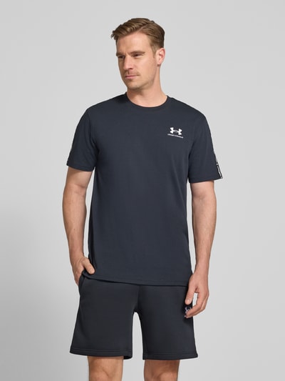 Männermodel trägt Regular Fit T-Shirt mit Logo-Stitching Modell 'Icon' von Under Armour aus Baumwoll-Mix, Rundhalsausschnitt, Dunkelblau, Herren T-Shirt, Rückenlänge 72 cm bei Größe M, Ganzkörperansicht von vorne.
