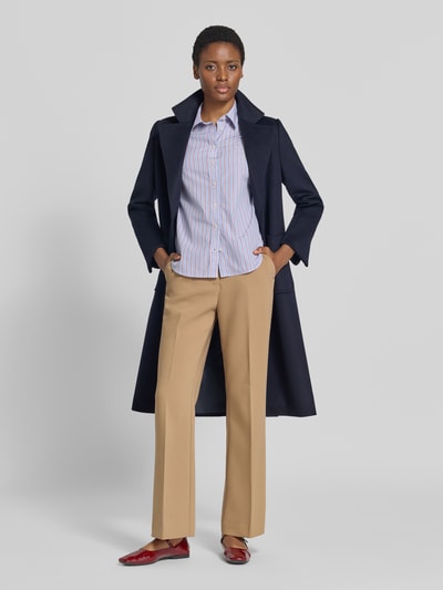 Frauenmodel trägt Regular Fit Langarmbluse aus reiner Baumwolle von GANT in hellem Blau mit feinen Streifen, Ganzkörperansicht von vorne.