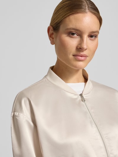Kobieta modelka nosi Regular Fit Blouson mit College-Kragen od Tom Tailor, efekt: jednolity kolor, krój regular fit, kształt kołnierza college, zamek błyskawiczny, długi rękaw, zakończenie rękawów i wykończenie elastyczne, wpuszczane kieszenie, wykończenie materiału: satyna; jasny odcień, gładka tekstura, zbliżenie na górną część ciała, widok z przodu