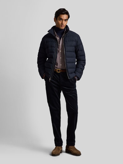 Männermodel trägt Custom Fit Freizeithemd aus reiner Baumwolle von Polo Ralph Lauren, kariertes Muster in Rot und Blau, Ganzkörperansicht von vorne.