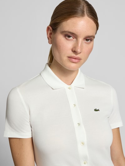 Vrouwenmodel draagt regular fit vrijetijdsjurk uit katoenmix, wit met kleine knopen, Regular Fit vrijetijdsjurk uit katoenmix van Lacoste, Nahaufnahme Oberkörper.