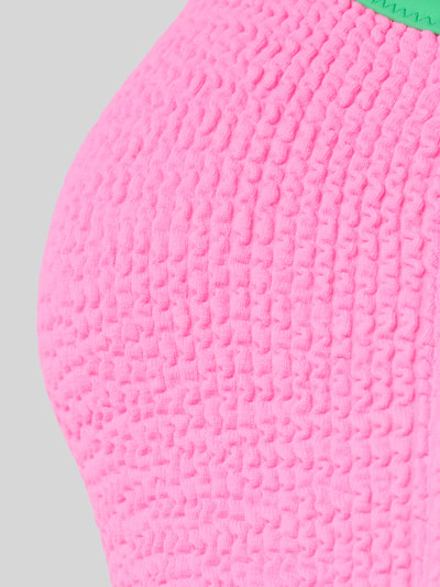 Produktfoto, Badeanzug mit Stretch-Anteil Modell 'SMAK POPMIX' von Banana Moon mit Strukturmuster, Colour-Blocking in Pink und Grün.