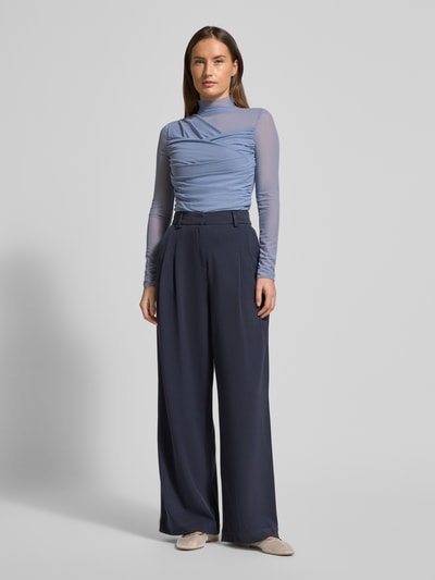 Frauenmodel trägt Slim Fit Langarmshirt aus semitransparentem Mesh Modell 'C_ETULAH' von BOSS Orange, Optik: Unifarben, Wickeloptik, hochgeschlossen, langarm, offene Kante, Materialverarbeitung: Mesh, Ganzkörperansicht von vorne.